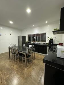 a kitchen with a table and chairs and a counter at Hostel Amarelinho in Brumadinho
