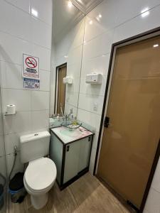 a bathroom with a toilet and a sink and a mirror at Hostel Amarelinho in Brumadinho +31 photos
