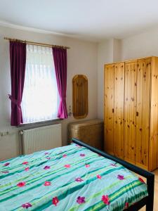 a bedroom with a bed and a window with purple curtains at Ferienwohnung Juttchen in Roßleben