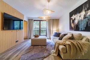 a living room with a couch and a tv at Ellivuori Asuinhuoneistot Apartments in Sastamala