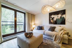 a living room with a couch and a large window at Ellivuori Asuinhuoneistot Apartments in Sastamala