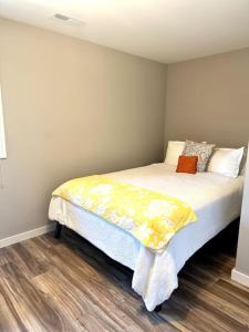 a bedroom with a bed with a yellow blanket on it at Panoramic Views in Ashland