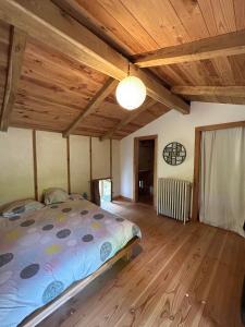 a bedroom with a bed in a room with wooden ceilings at Le Mas du Savel in Gagnières