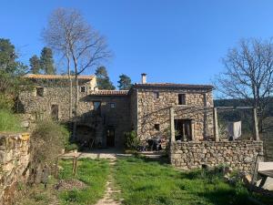 an old stone house with a pathway in front of it at Le Mas du Savel in Gagnières