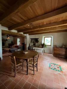 a living room with a wooden table and chairs at Le Mas du Savel in Gagnières