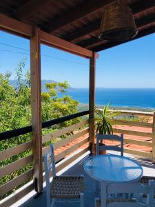 a table and chairs on a porch with a view of the ocean at Apartment in Marathokampos Samos in Samos