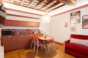 a kitchen and dining room with a table and a red couch at My Trevi Suite & Apartment in Rome