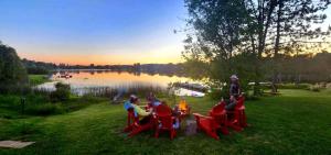 Un groupe de personnes assises autour d'une table au bord d'un lac dans l'établissement Le Duc on the Lake - Cozy waterfront Cottage, à Saint-André-Avellin 46 autres photos