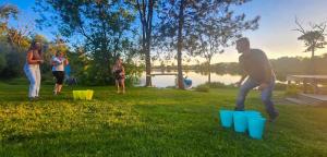 un groupe de personnes jouant avec des gobelets en plastique dans l'herbe dans l'établissement Le Duc on the Lake - Cozy waterfront Cottage, à Saint-André-Avellin