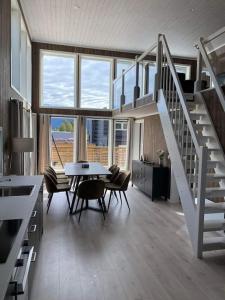 un soggiorno con una scala, un tavolo e delle sedie di Trivelig og nylig oppført hytte med innendørs peis a Vrådal