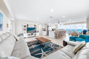 un soggiorno con un divano bianco e un tavolo di Jamaica Royale Beachfront Tower By Beachside Management a Siesta Key