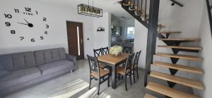 a dining room and kitchen with a table and a clock at Domki i Pokoje u Ilony in Krościenko