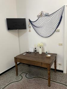 a living room with a table and a hanging hammock at Il Delfino d'Oro in Savona