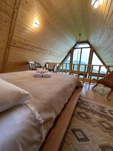 a large bed in a room with a large window at Cottage KOLKHA in Sarpi