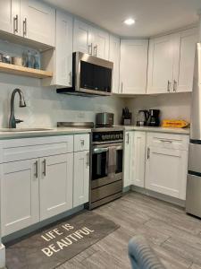 une cuisine avec des armoires blanches et des appareils en acier inoxydable dans l'établissement Beach Living at Island Pine Villas 'BLJW', à George Town