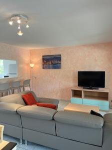 a living room with a couch and a flat screen tv at Les Villas Maristella, Villa Oriente in Aregno