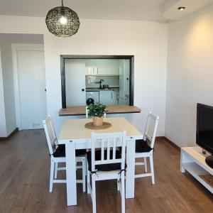 a dining room with a white table and chairs at CALA PUNTAL COSTA SUR Vinaròs NG in Vinaròs +21 photos