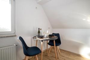 a small table with two chairs and a bottle of wine at 110 qm Penthousewohnung bei Bonn / Köln in Lohmar +19 photos