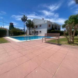 a bench sitting next to a swimming pool at CALA PUNTAL COSTA SUR Vinaròs NG in Vinaròs