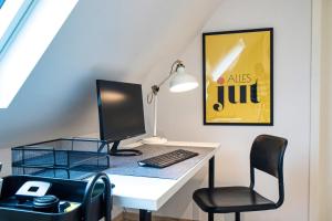 a desk with a computer and a chair at 110 qm Penthousewohnung bei Bonn / Köln in Lohmar