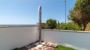 a pole against a white wall with a fence at Sardinianworld - Casa Dei Bucanieri in Putzu Idu