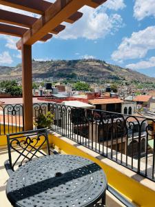 a table on a balcony with a view of a city at Hotel Casa Rubio in Atotonilco el Alto +11 photos