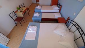 a small room with two beds and a table at Amalia in Stavros +10 photos