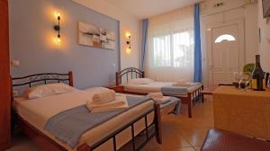 a hotel room with two beds and a table and a room at Amalia in Stavros