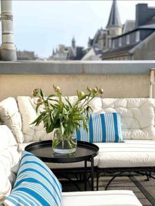 a vase of flowers on a table next to a couch at Charming Penthouse in the City Center in Luxembourg