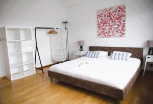 a bedroom with a large bed and white furniture at Charming Penthouse in the City Center in Luxembourg
