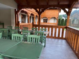 a cafeteria with green tables and chairs on a wooden deck at CABANA ZIMBRU in Băile Borşa