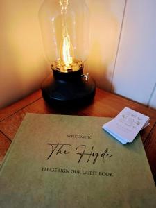 a lamp sitting on a table with a guest book at Luxury Shepherd's Hut - The Hyde in Reading