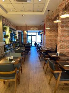 a restaurant with tables and chairs and a brick wall at Quarto em hotel pertinho do Aeroporto de Congonhas - H2208 in São Paulo