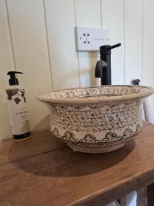 a sink on a wooden table with a bottle of wine at Luxury Shepherd's Hut - The Hyde in Reading +17 photos