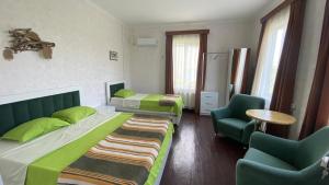una camera d'albergo con due letti e due sedie di Megruli House a Poti