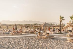 a group of lounge chairs and umbrellas on a beach at Apartments Contessa in Ulcinj
