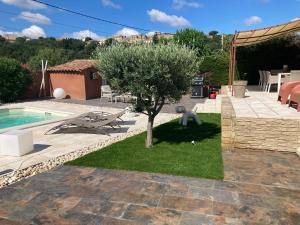 a garden with a tree and a swimming pool at La Cigale in Castillon-du-Gard