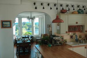 a kitchen with a table and a dining room at Glenaros Lodge in Salen