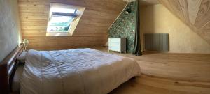 a bedroom with a bed in a wooden room at Gîte de la Ressourcery in Sainte-Marie-du-Mont