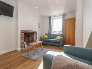 a living room with a couch and a table at 2 South Street in Wigton