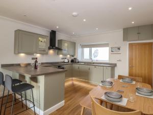 an open kitchen and dining room with a wooden table at 2 South Street in Wigton