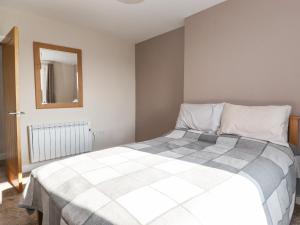 a bedroom with a bed and a mirror at 2 South Street in Wigton