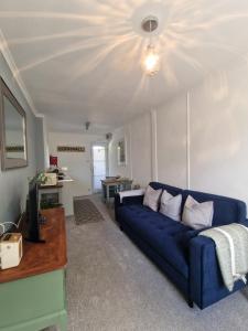 a living room with a blue couch and a table at Olive Cottage Small bolt hole close to Carbis Bay Beach & St Ives in Carbis Bay