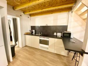 a kitchen with white cabinets and a counter with a microwave at La mezzanine Rouennaise in Rouen +4 photos