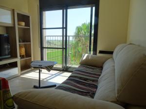 a living room with a couch and a large window at Apartamento con vistas in Camarles