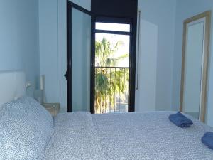 a bedroom with a bed with a view of a palm tree at Apartamento con vistas in Camarles