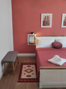 a bedroom with a bed with a red wall at Te Amantia Apartment in Tirana