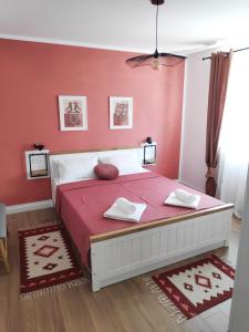 a bedroom with a large bed with pink walls at Te Amantia Apartment in Tirana