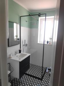 a bathroom with a sink and a glass shower at Te Amantia Apartment in Tirana +23 photos