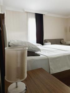 a hotel room with a bed and a table with a lamp at Palm Beach Hotel in Anaklia